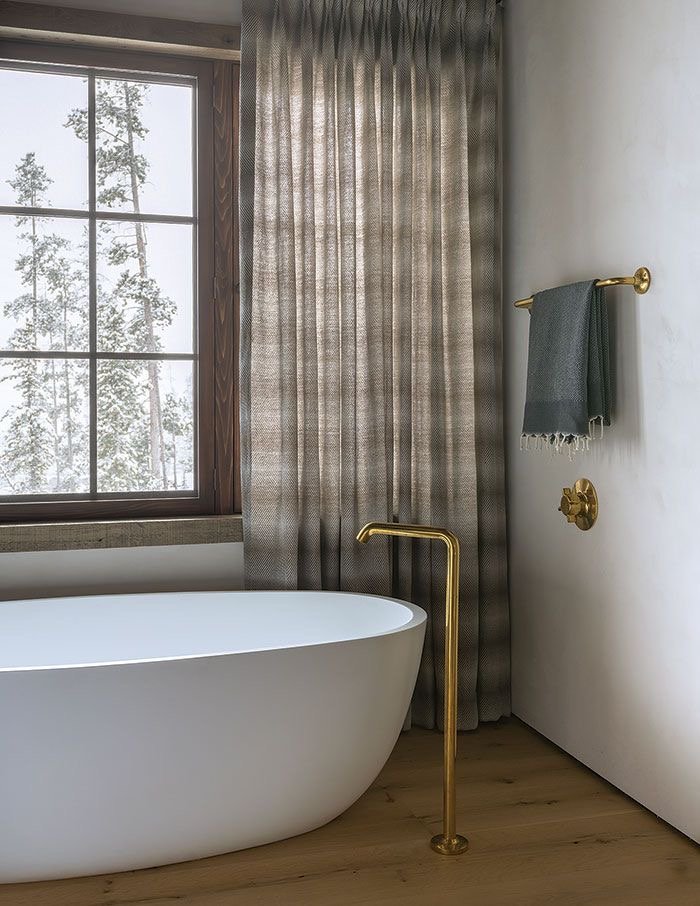 Classic fixtures paired with this soaking tub create a spa environment in this mountain home..