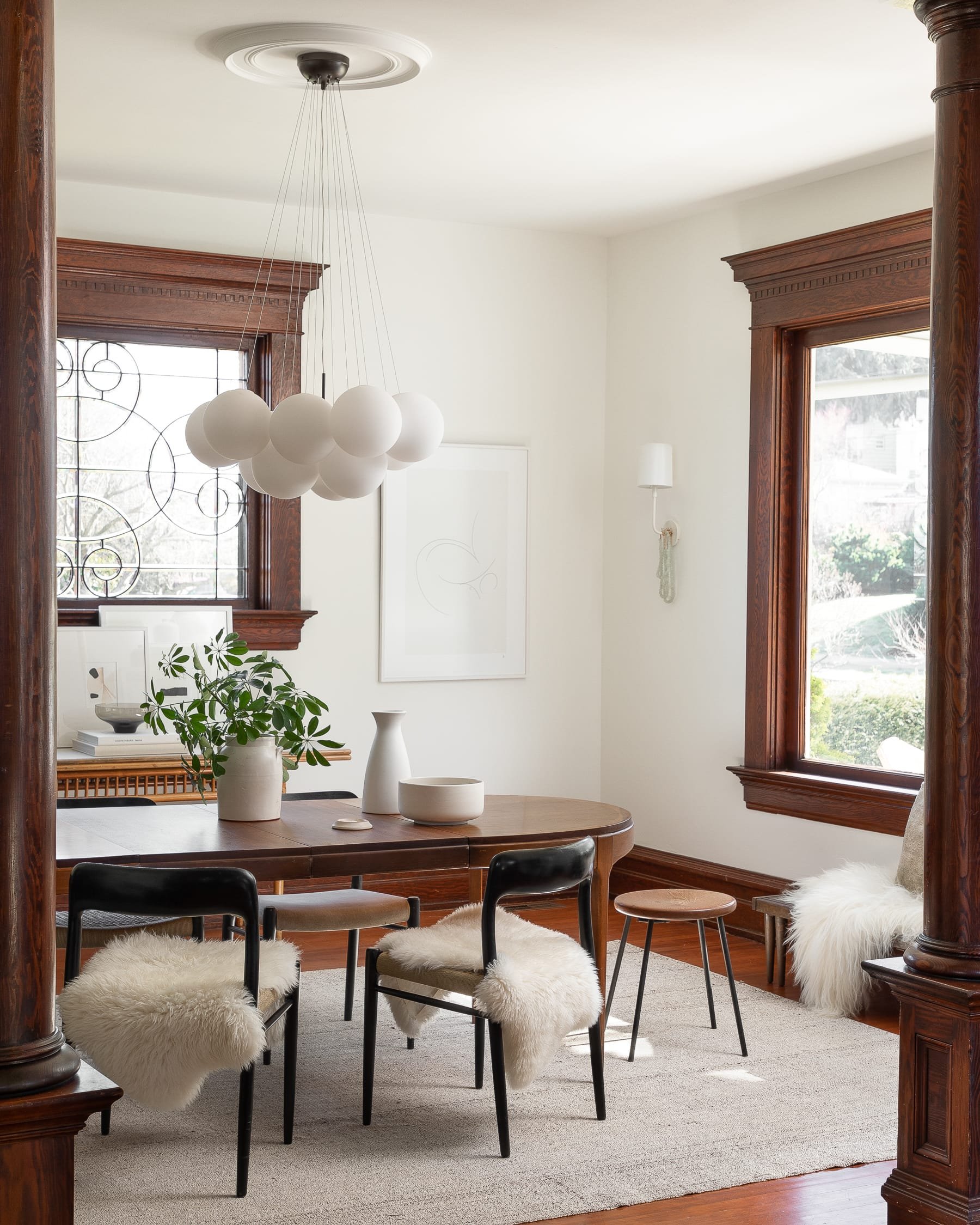 dining room in victorian home with modern light fixture and vintage furniture