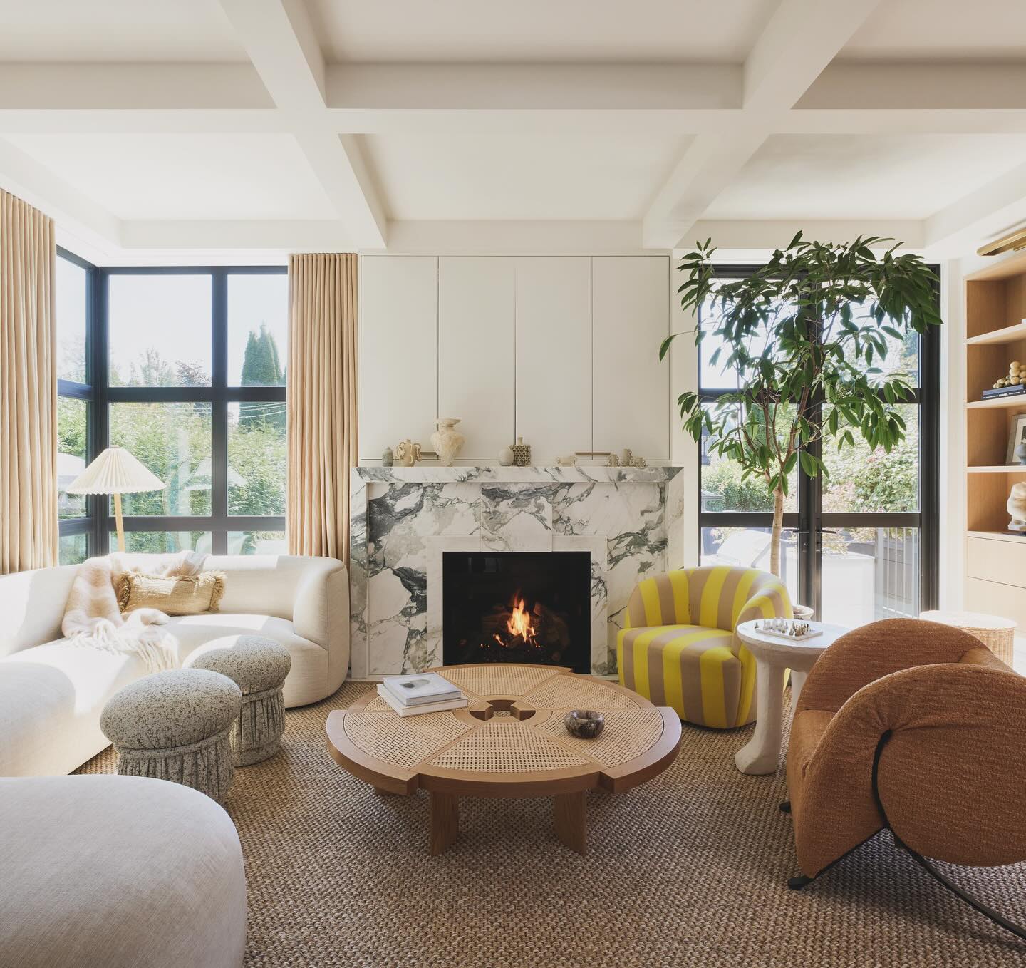 bright living room with a marble fireplace and a hidden TV behind cabinet doors. California living and high-end interior designer in Sacramento